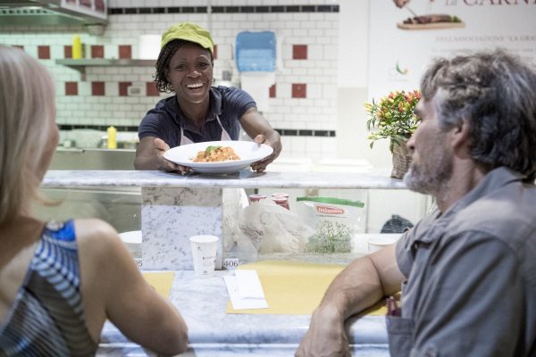 Italy. Refugee chef Meirelle serves her dish